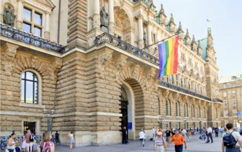 Frontseite des Hamburger Rathauses mit Regenbogenflagge