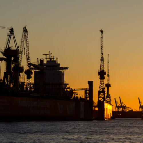 Kräne im Hamburger Hafen bei Sonnenuntergang im Panorama