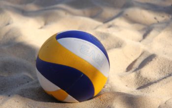 Nahaufnahme eines Volleyballs, der im Sand liegt