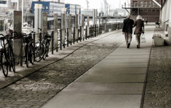 Rückansicht eines Paares aus der Entfernung, das in der Hamburger HafenCity spazieren geht