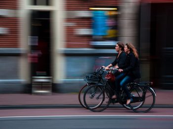 zwei Radfahrerinnen, die auf einem roten Radfahrstreifen nebeneinander fahren