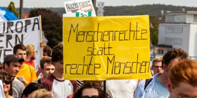 Demo mit Schild "Menschenrechte statt rechte Menschen"